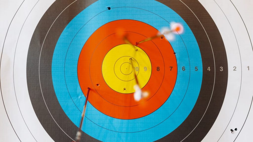 Close-up of a colorful archery target with perfectly hit arrows showcasing precision.